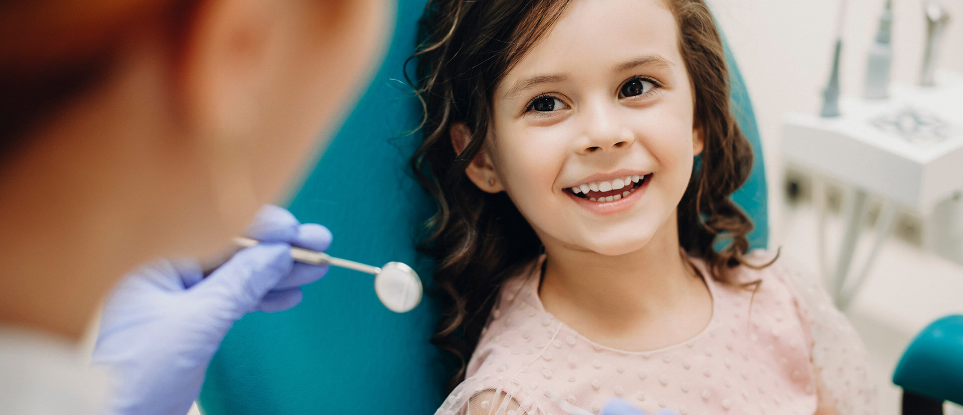 a child is smiling while receiving an dental exam