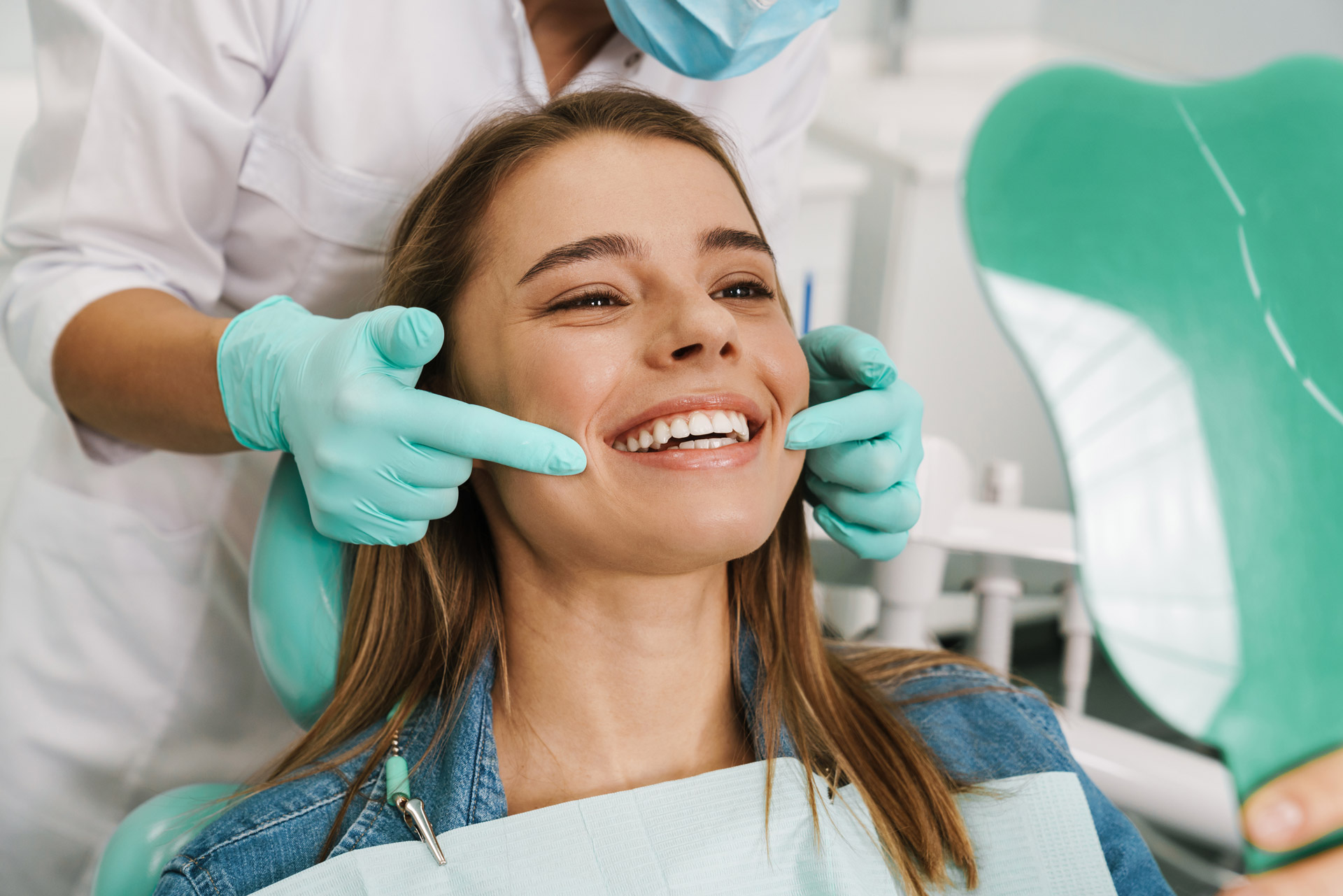 dentist showing patient a fully installed custom dental veneers set