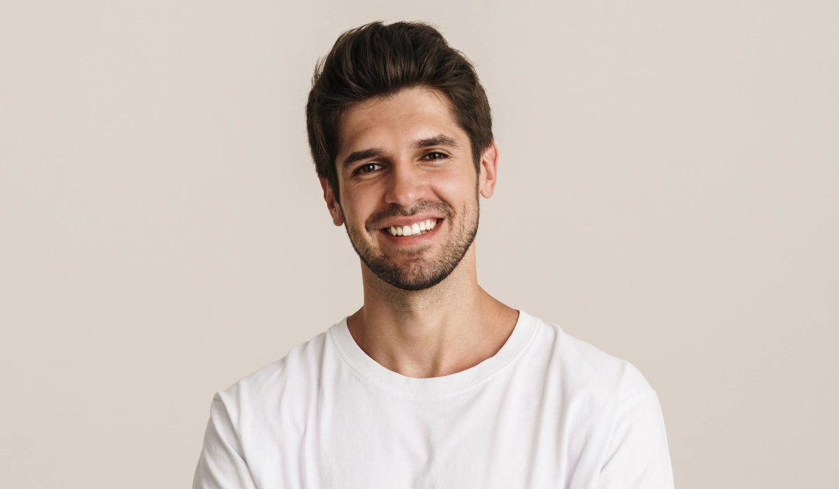 A smiling man in a white T-shirt with a bright, natural smile.