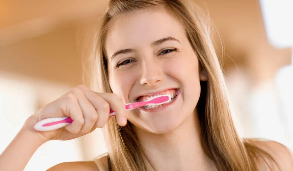 Teen girl brushing her teeth as part of her daily dental routine
