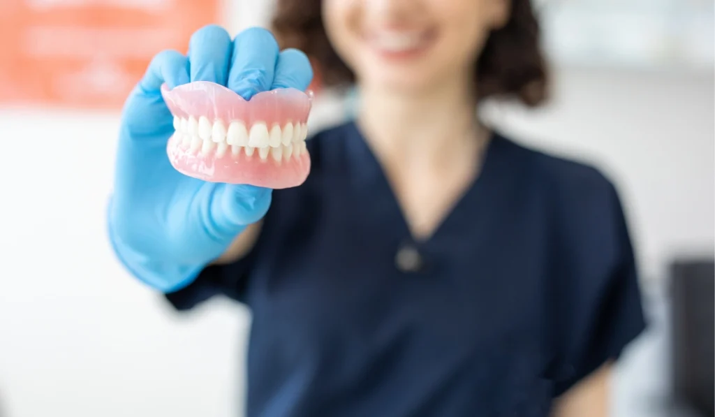 Dentist holding a model of complete dentures
